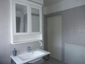 La salle de bains blanche est pourvue d'un lavabo et d'un miroir. dans l'établissement holiday home, Perros-Guirec, à Perros-Guirec