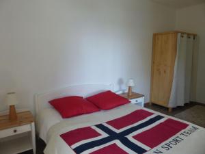 - une chambre avec un lit doté d'oreillers rouges et bleus dans l'établissement holiday home, Perros-Guirec, à Perros-Guirec
