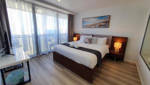 a bedroom with a large bed and a large window at OceanView Oasis 2BR Apt - 5Mins to Beach - Family Resort in Gold Coast