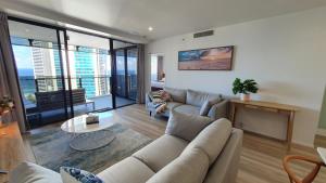 a living room with a couch and a table at Luxury Oceanview Apartment on Lvl 24 in Gold Coast