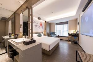 una camera d'albergo con un letto e un lavandino di Paco Hotel Canton Tower Pazhou a Canton