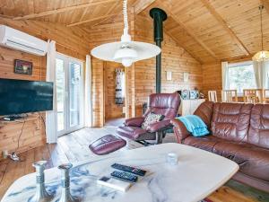 uma sala de estar com mobiliário de couro e uma televisão de ecrã plano em Holiday Home Fjordternevej em Sindrup