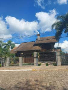 um edifício com uma cerca em frente em Casa de Pedra-Vale dos Vinhedos -RS em Monte Belo