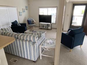 a living room with two couches and a tv at Montego Bay - South Ocean Drive 203 in Ocean City