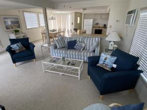 a living room with two blue chairs and a couch at Montego Bay - South Ocean Drive 203 in Ocean City