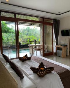 a bedroom with a bed with two pillows on it at Ubud Paras Villa in Ubud