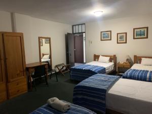 um quarto de hotel com duas camas e uma secretária em Hotel Las Mercedes em Trujillo