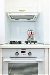un forno bianco a piano cottura in una cucina bianca di My Hotel Apartments a Bucarest