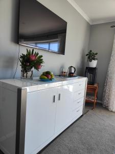 a white kitchen with a counter with fruit on it at Courtenay B & B in Kaiapoi