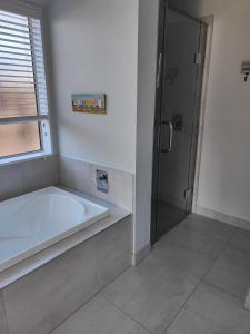 La salle de bains est pourvue d'une baignoire et d'une douche. dans l'établissement Courtenay B & B, à Kaiapoi