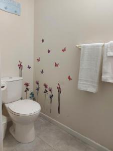 a bathroom with a toilet and butterflies on the wall at Richter Pass Beach Resort in Osoyoos