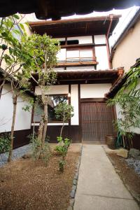 un edificio con una puerta y árboles delante de él en HEM'S HOTEL 1日1組限定 new en Miyajima