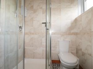 a bathroom with a toilet and a glass shower at Garden View in Newquay +28 photos