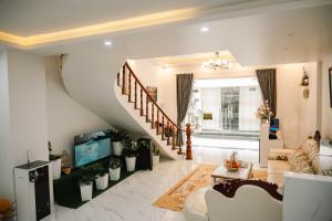 a living room with a staircase and a tv at Hailey's House in Da Lat