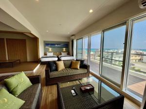 恩納村にあるCoral Palace Onna by Sunset Avenueのベッド付きのホテルルームで、海の景色を望めます。