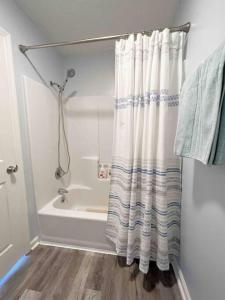 La salle de bains est pourvue d'un rideau de douche et d'une baignoire. dans l'établissement Cozy house near Douglas Lake Family and Pet friendly Quiet location, à Sevierville