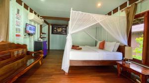 a bedroom with a bed with a mosquito net at Koh Yao Seaview Bungalow in Ko Yao Noi