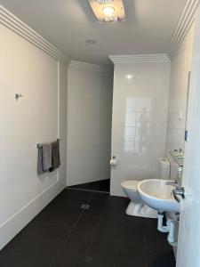a bathroom with a white toilet and a sink at Oriental Hotel Tumut in Tumut