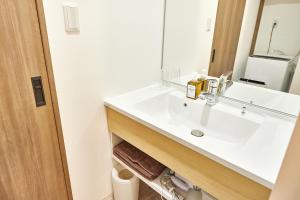 y baño con lavabo blanco y espejo. en A.A.O BLDG. NAMBA en Osaka