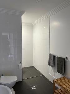 a white bathroom with a toilet and a shower at Oriental Hotel Tumut in Tumut