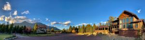 a building on a road next to a mountain at Summit Mountain Lodge and Steakhouse in East Glacier Park