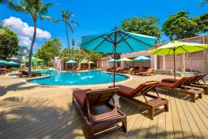 una terraza con sillas y sombrillas junto a una piscina en Baan Samui Resort - SHA Extra Plus en Chaweng Beach