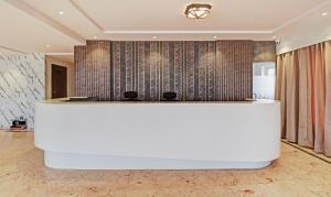a lobby with a large white reception desk at Treebo Trend Emora Grand in Yelahanka