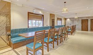 a dining room with a long table and chairs at Treebo Trend Emora Grand in Yelahanka