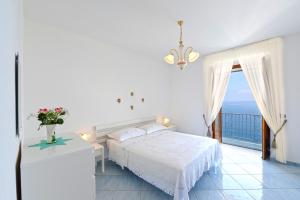 une chambre avec un lit et une vue sur l'océan dans l'établissement Moressa, à Praiano