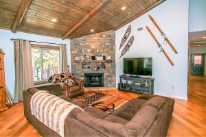 een woonkamer met een bank en een open haard bij Alpine Chalet-1840 by Big Bear Vacations in Big Bear Lake