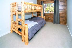 een houten stapelbed in een kamer met een raam bij Alpine Chalet-1840 by Big Bear Vacations in Big Bear Lake