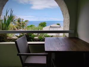a table and chairs on a balcony with a view of the ocean at Le Victoria in Saint-Pierre