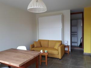 ein Wohnzimmer mit einem Sofa und einem Tisch in der Unterkunft Les Marinières d'Oléron in Boyard-Ville
