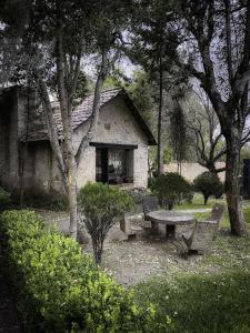 a stone building with a picnic table and trees at Hotel Hacienda San Miguel Regla in Huasca de Ocampo