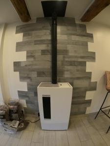 a brick wall with a woodburning stove in a room at Appartement cocooning pour un séjours à Tende in Tende