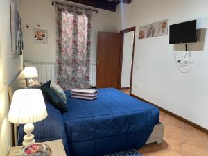 Un pequeño dormitorio con una cama azul y una mesa en Via G Mameli 94 ZTL zona tempo libero, en Spoleto