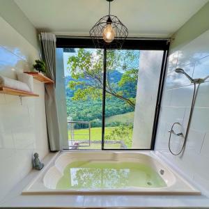 a bath tub in a bathroom with a large window at Estadero Bello Horizonte in Florencia