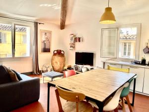 a living room with a wooden table and a couch at Lumineux Aix Plein Centre avec Parking privé Gratuit in Aix-en-Provence