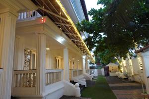 a building with white columns and a walkway at Lillywoods Zac Beach Resort, Calangute in Goa Velha