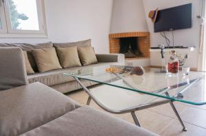 a living room with a glass table in front of a couch at Villa Afroditi in Agia Triada