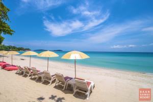 een rij stoelen en parasols op een strand bij Baan Samui Resort - SHA Extra Plus in Chaweng Beach