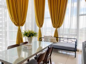 a living room with a table and a bed and windows at The Luxe @ EvoSoho Suites in Kampong Sungai Ramal Dalam