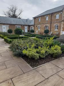 a garden in front of a brick building at The Stables a Contractor Family 2 bed Town House in Central Melton Mowbray in Melton Mowbray