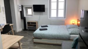 Cette petite chambre dispose d'un lit, d'une table et d'un sidx de table. dans l'établissement Jolis Appartements au coeur de Clermont Ferrand - Proche Jaude - WIFI et NETFLIX, à Clermont-Ferrand