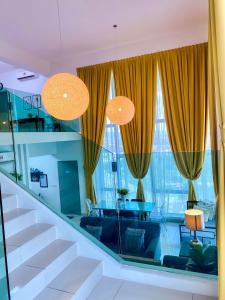 a living room with yellow curtains and a staircase at The Luxe @ EvoSoho Suites in Kampong Sungai Ramal Dalam
