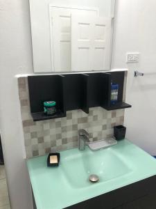 a bathroom counter with a sink and a mirror at Beverley Manor DIAMOND VALE' 2 Bedroom 1 Bath Apartment in Diego Martin