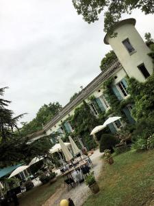 カストルにあるドメーヌ ドゥ ラ ヴィヴァリエの目の前にテーブルと傘が置かれた大きな建物