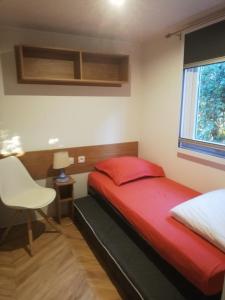 a bedroom with a red bed and a window at Le Casita 3 ch, au calme, sur parcelle arborée in Lattes