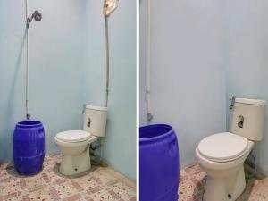 La salle de bains est pourvue de 2 toilettes et d'un mur bleu. dans l'établissement OYO 91005 Cottage Putra Mutun Beach, à Bandar Lampung