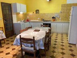 uma cozinha com mesa e cadeiras e uma cozinha com paredes amarelas em La corderie em Sigean